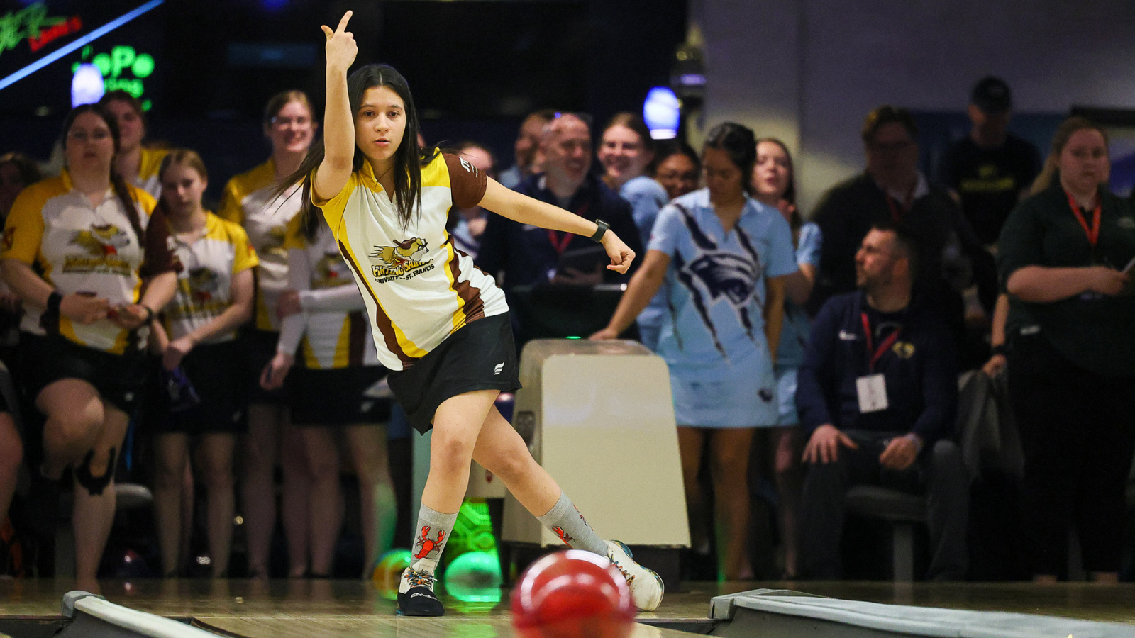 University of Saint Francis Women’s bowling player throwing a red bowling ball.