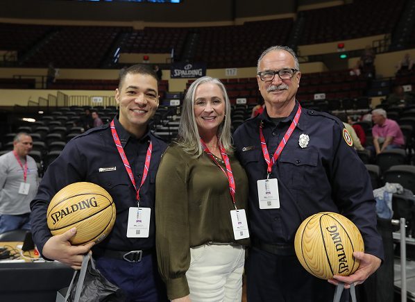 first responders stand with woman and basketballs