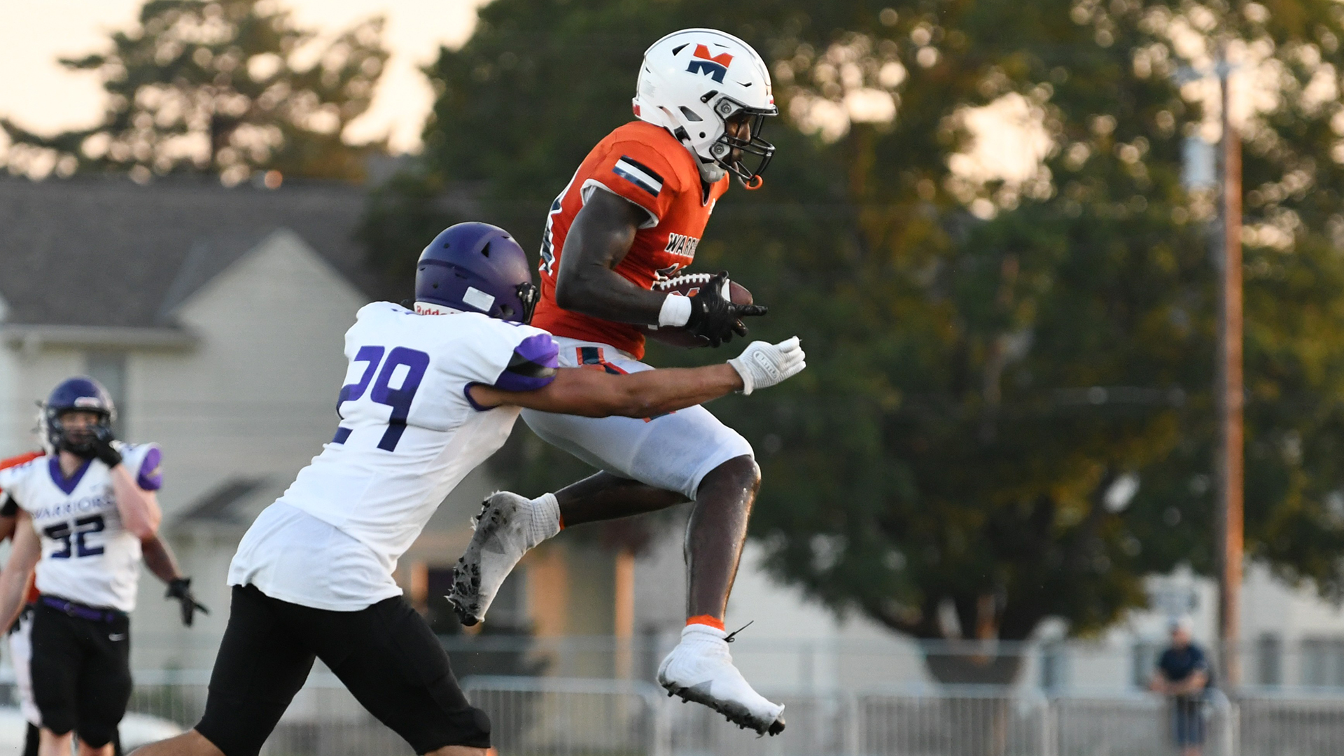 Jurrion Dickey, wearing an orange jersey, catches a pass.