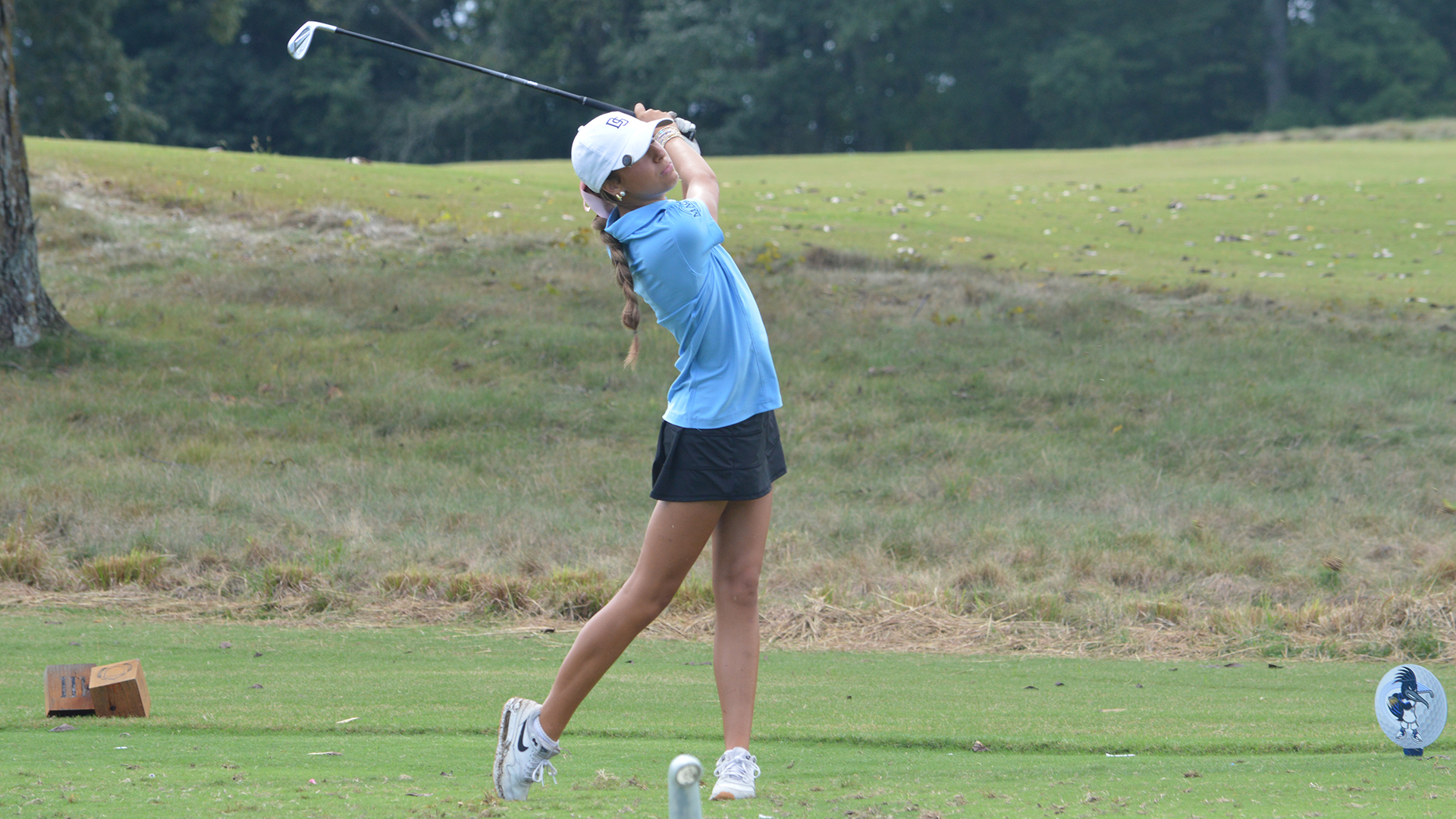 Reese Day swings a golf club on the tee box.
